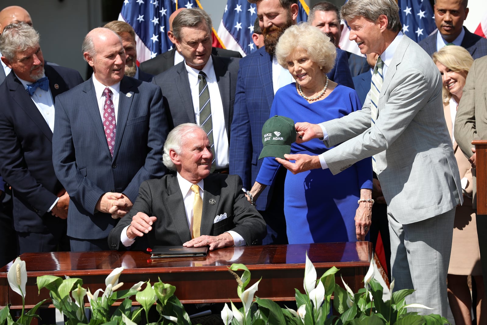 South Carolina Sen. Luke Rankin, R-Myrtle Beach, right, hands Republican Gov. Henry McMaster, left, a Santee Cooper hat during a ceremony to celebrate a law changing South Carolina energy policy on Wednesday, June 18, 2025, in Columbia, S.C. (AP Photo/Jeffrey Collins)
