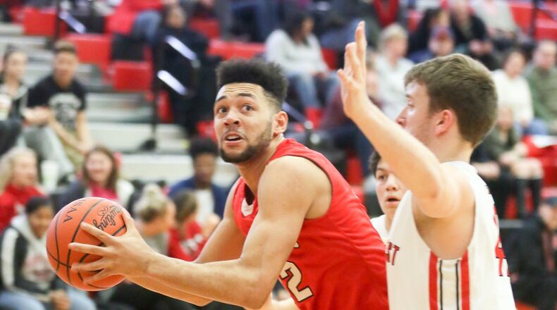 Fairfield forward Ben Phillips (42) takes a shot while being defended by Lakota West forward Cameron Anzer (42) during their game at West on Jan. 31. GREG LYNCH/STAFF