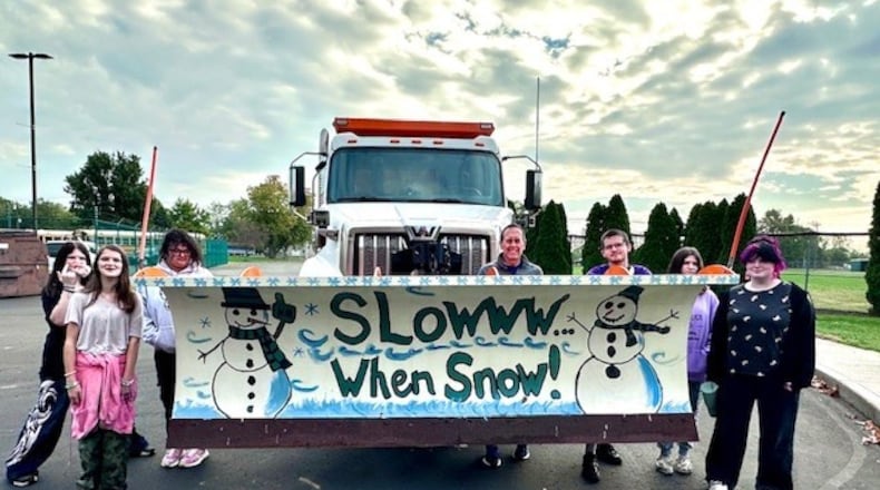 Students are seen here with New Miami High School Teacher Kevin Mazes. This group painted a snow plow blade to be used this winter by the Butler County Engineer's Office. BCEO/CONTRIBUTED