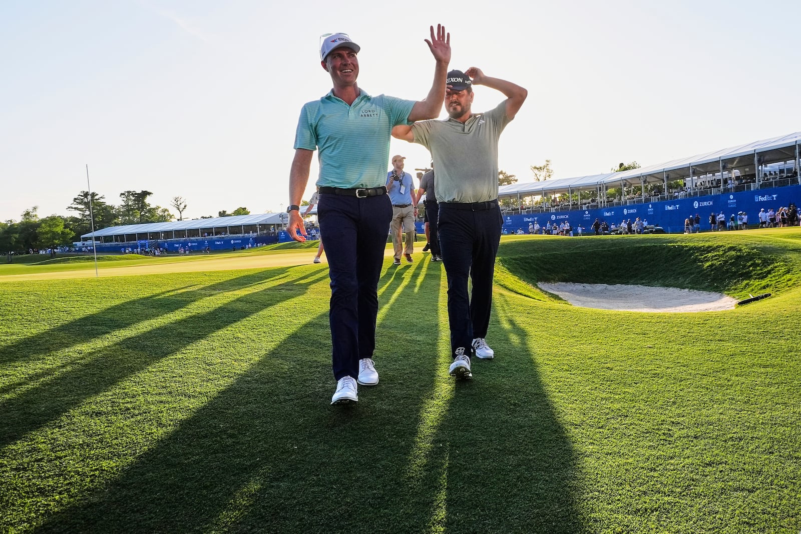 Ben Griffin, left, walks off the 18th green with teammate Andrew Novak, after they won the PGA Zurich Classic golf tournament at TPC Louisiana in Avondale, La., Sunday, April 27, 2025. (AP Photo/Gerald Herbert)