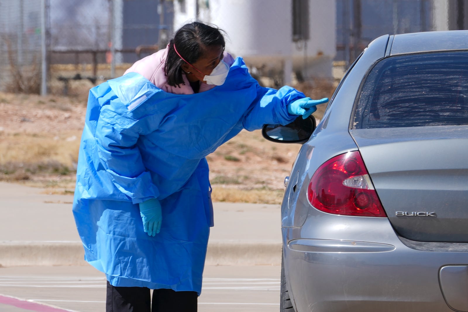FILE - A health worker talks to people before administering measles tests outside Seminole Hospital District, Feb. 21, 2025, in Seminole, Texas. (AP Photo/Julio Cortez, File)