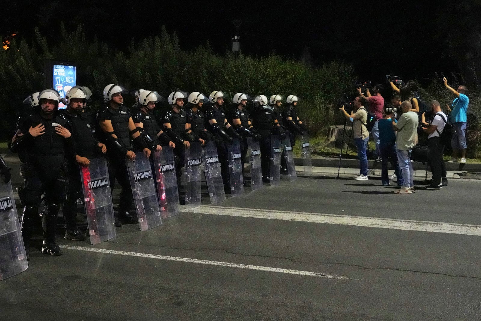Riot police block a street to prevent clashes between anti-government protesters and government supporters at the end of a rally pressing for an early election after nearly eight months of almost daily anti-corruption demonstrations that have shaken the populist government of President Aleksandar Vucic, in Belgrade, Serbia, Saturday, June 28, 2025. (AP Photo/Darko Vojinovic)