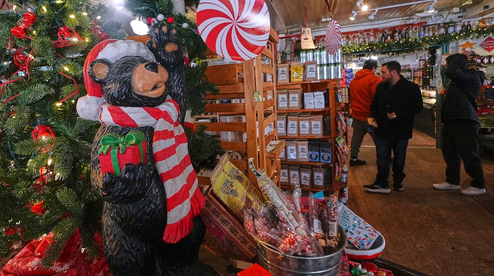 Post-holiday shoppers pass a Christmas tree and festive display at Calef's Country Store, Friday, Dec. 26, 2025, in Barrington, N.H. (AP Photo/Charles Krupa)