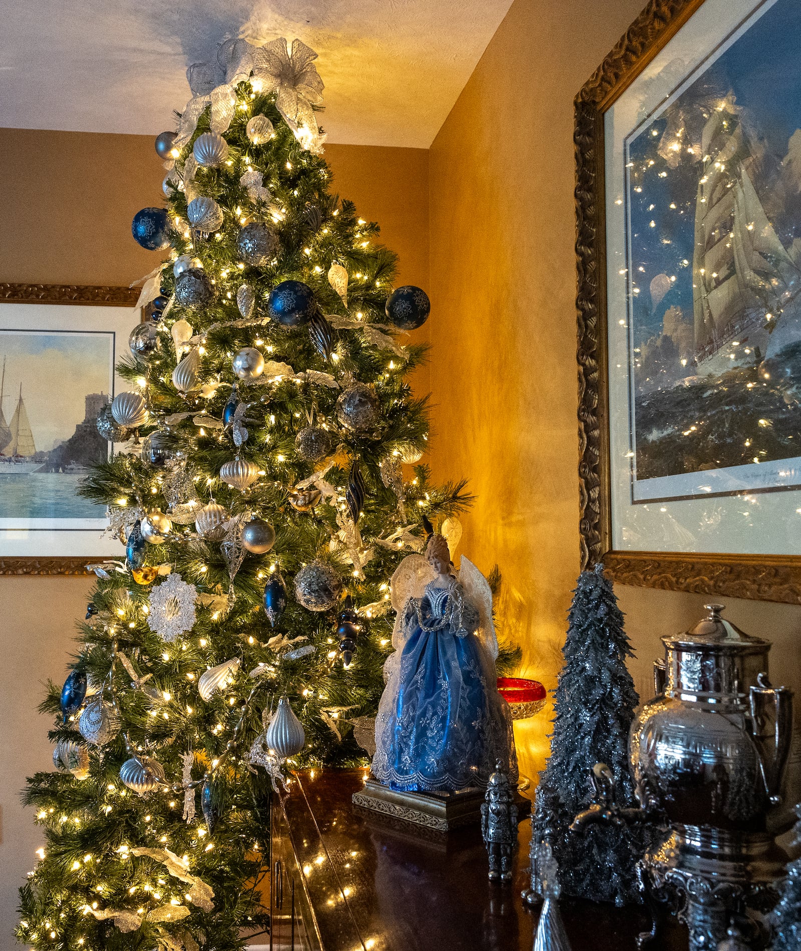 A 12-foot tree in the dining room of the Wales' home in Miami Twp. shimmers with silver, blue and white lights.  BRYANT BILLING/STAFF 