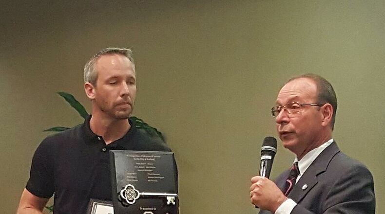 Jeff Herold, president of the Fairfield Optimist Club, accepts honors bestowed on the club in celebration of its 60th anniversary from Fairfield Mayor Steve Miller at the Sept. 12, 2016, city council meeting.