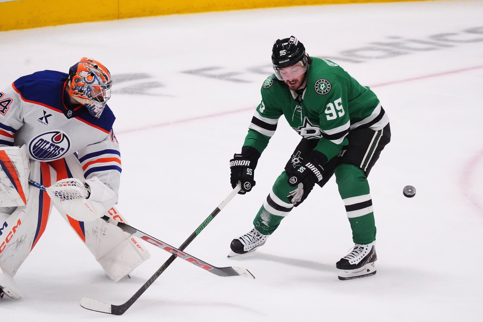 Edmonton Oilers goaltender Stuart Skinner (74) moves the puck as Dallas Stars center Matt Duchene (95) close in during the third period in Game 1 of the Western Conference finals in the NHL hockey Stanley Cup playoffs Wednesday, May 21, 2025, in Dallas. (AP Photo/LM Otero)