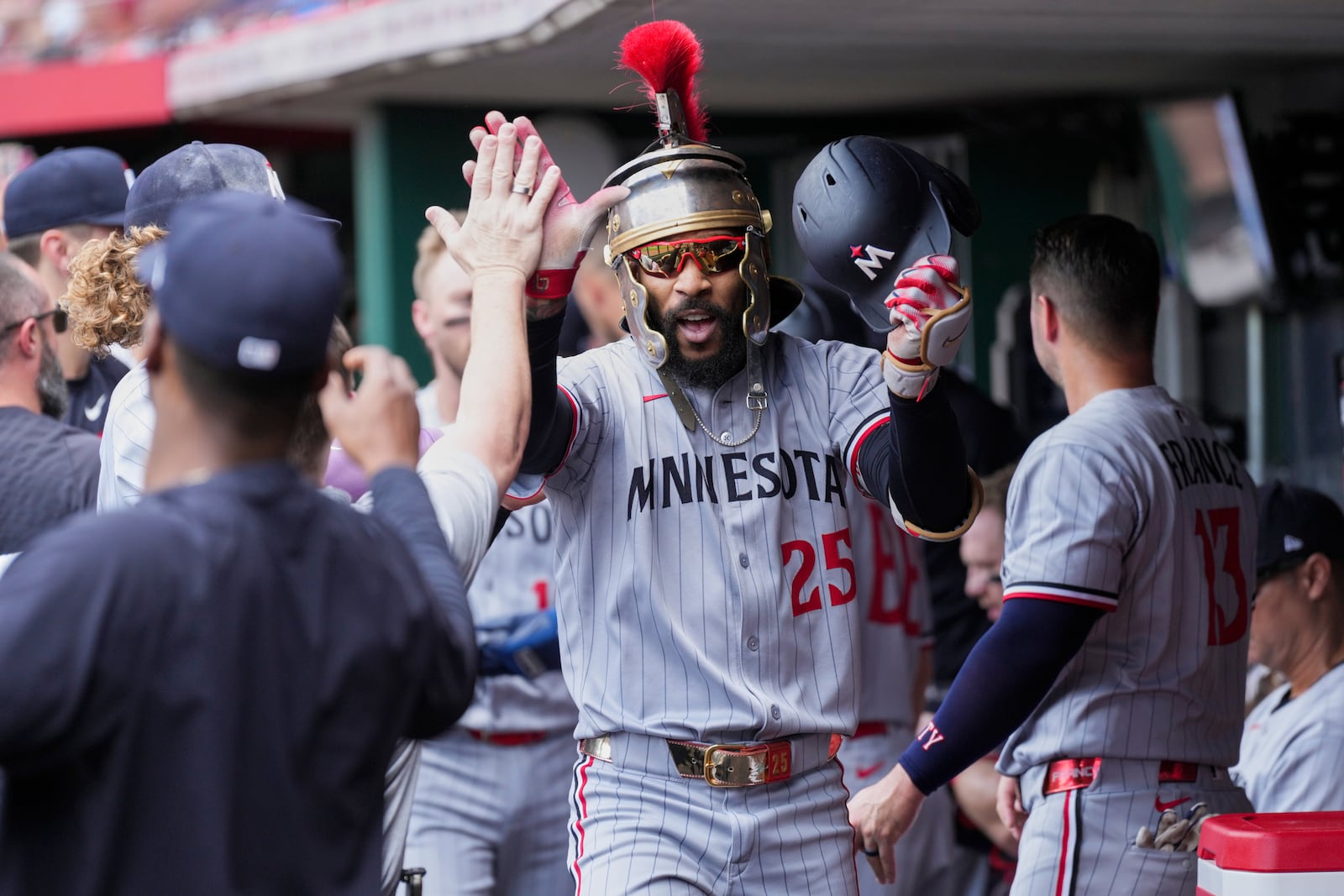 Minnesota Twins' Byron Buxton celebrates in the dugout hitting the the second in back-to-back home runs during the second inning of a baseball game against the Cincinnati Reds, Thursday, June, 19, 2025, in Cincinnati. (AP Photo/Grace Bradley)