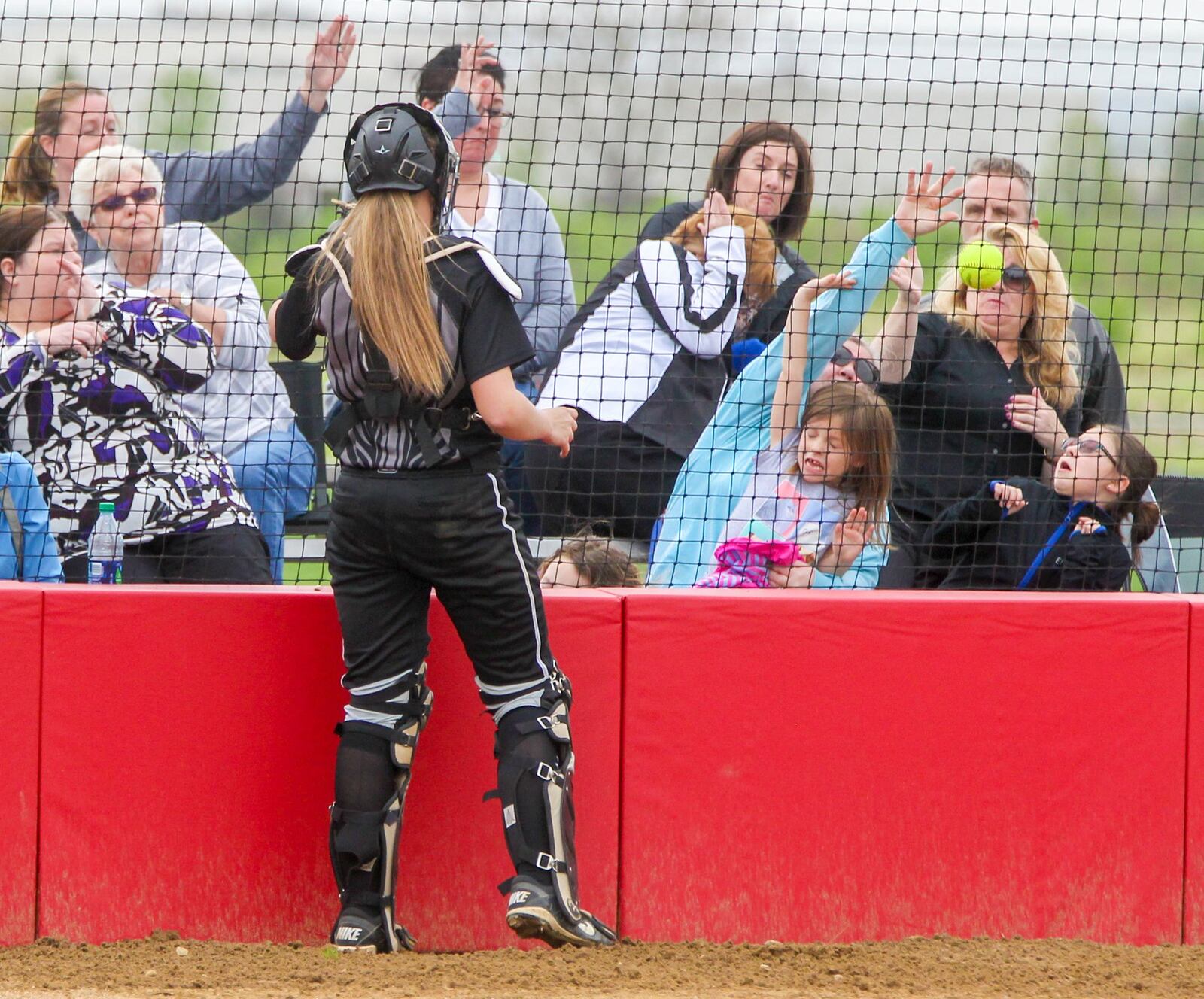 Fans dive for cover as a foul ball heads their way during the Lakota East-Lakota West game Tuesday in West Chester Township. GREG LYNCH/STAFF
