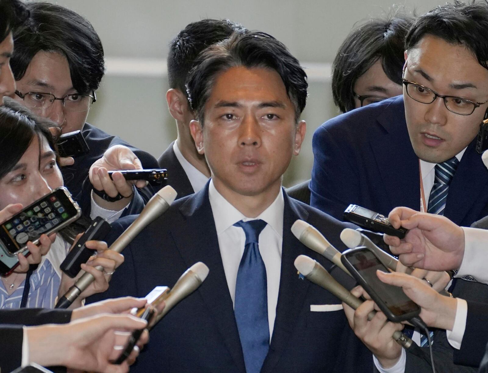 Former Environment Minister Shinjiro Koizumi, center, is surrounded by reporters at the prime minister's office in Tokyo Wednesday, May 21, 2025. (Kyodo News via AP)