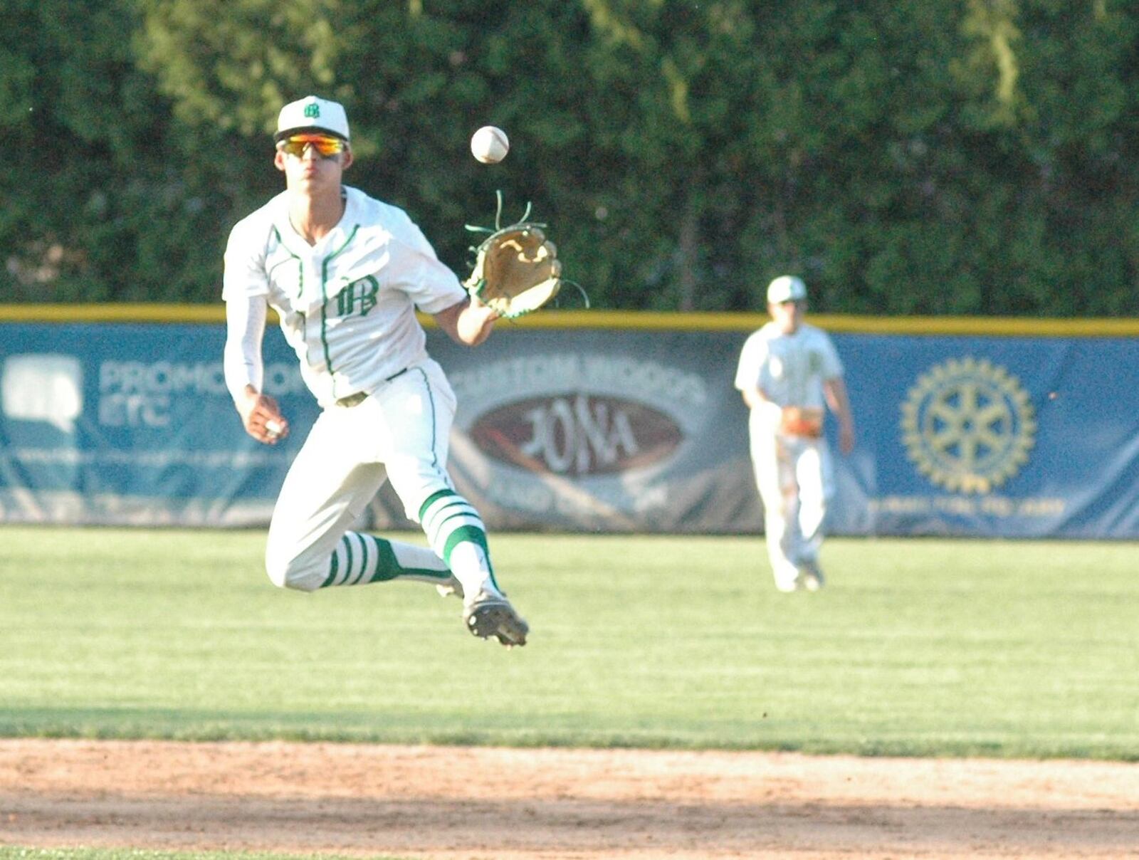 Badin shortstop Sergio DeCello goes airborne on a throw across the diamond Monday night during a Butler County baseball game against visiting Ross at Alumni Field in Joyce Park. Badin won 6-2. RICK CASSANO/STAFF