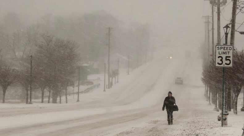 A woman walks in the snow along Main Street in Englewood Thursday afternoon