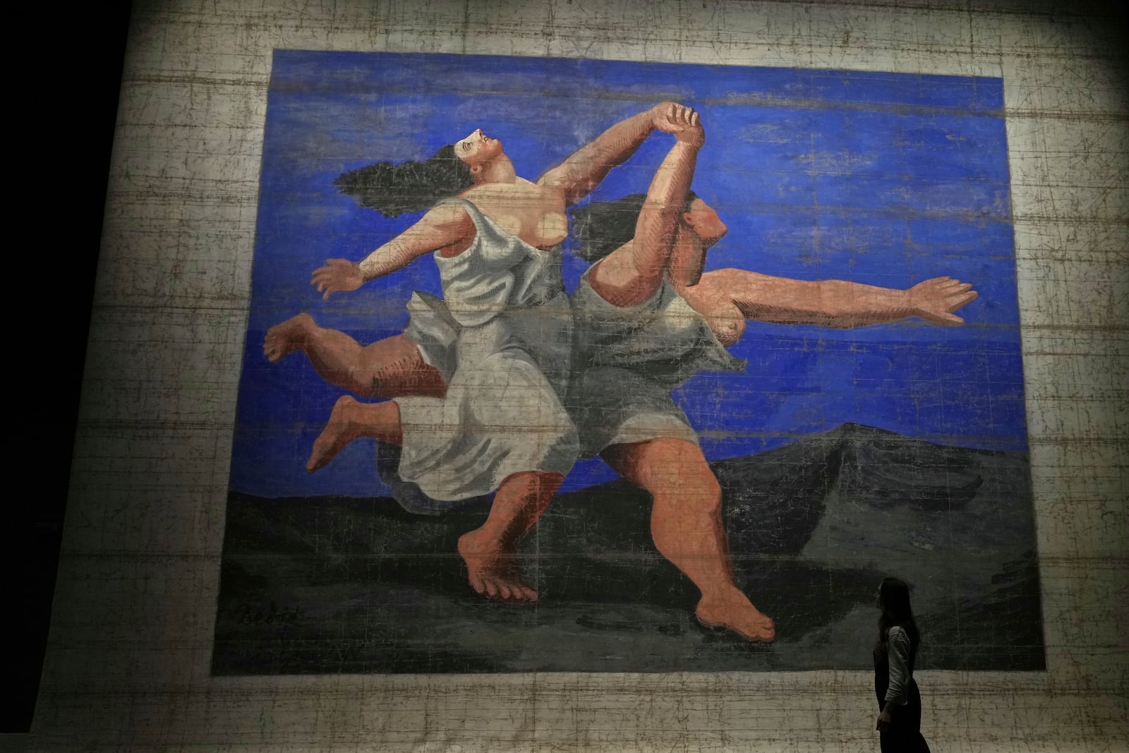 Le Train Bleu, a theatre front cloth painted by Prince Alexander Schervashidze, which is based on Pablo Picasso's "The two women running along the beach", on display at the V&A Storehouse in London, Thursday, June 5, 2025. (AP Photo/Joanna Chan)