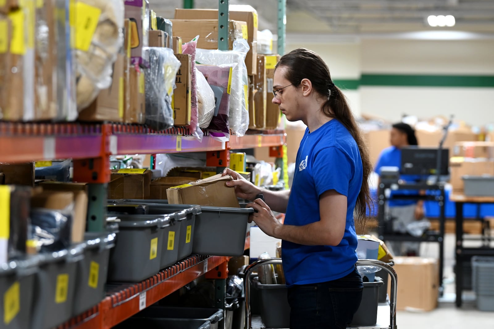 MAC.BID, an online auction retailer, and its Yinz Binz retail store, is open for business at 1204 Main St., on Hamilton's west side. They are open from noon to 6 p.m. seven days a week. Pictured is Jayge Angevine (CQ), of Hamilton, stocking auction item shelves on Thursday, Aug. 21, 2025. MICHAEL D. PITMAN/STAFF