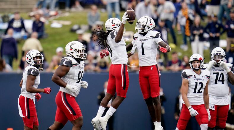 Cincinnati cornerback Arquon Bush, center left, celebrates with Ahmad Gardner (1) after intercepting a pass intended for Navy fullback Chance Warren, not visible, during the second half of an NCAA college football game, Saturday, Oct. 23, 2021, in Annapolis, Md. Cincinnati won 27-20. (AP Photo/Julio Cortez)