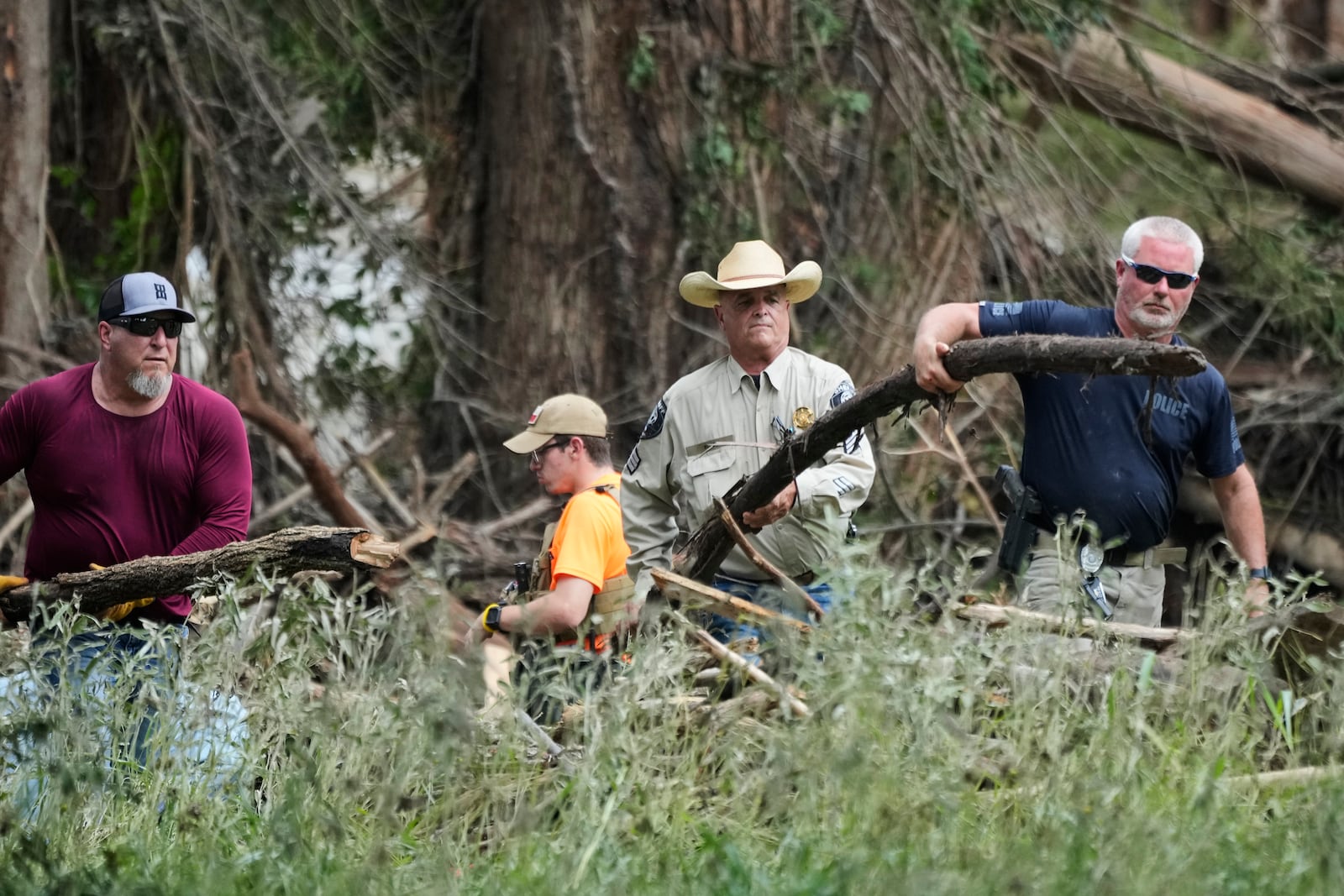 Law enforcement assist during clean-up efforts in Center Point, Texas, Monday, July 7, 2025. (AP Photo/Ashley Landis)