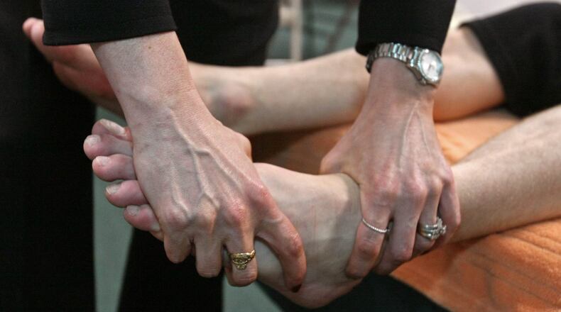 A chiropractic adjusted the feet of dancer from the Atlanta Ballet to help relieve the physical stress that the dancer’s body goes through during his performances. JASON GETZ /AJC FILE