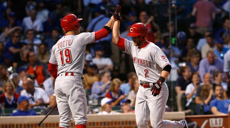 Cincinnati Reds’ Zack Cozart (2) celebrates his home run off Chicago Cubs starting pitcher Kyle Hendricks with Joey Votto during the third inning of a baseball game Wednesday, May 17, 2017, in Chicago. (AP Photo/Charles Rex Arbogast)