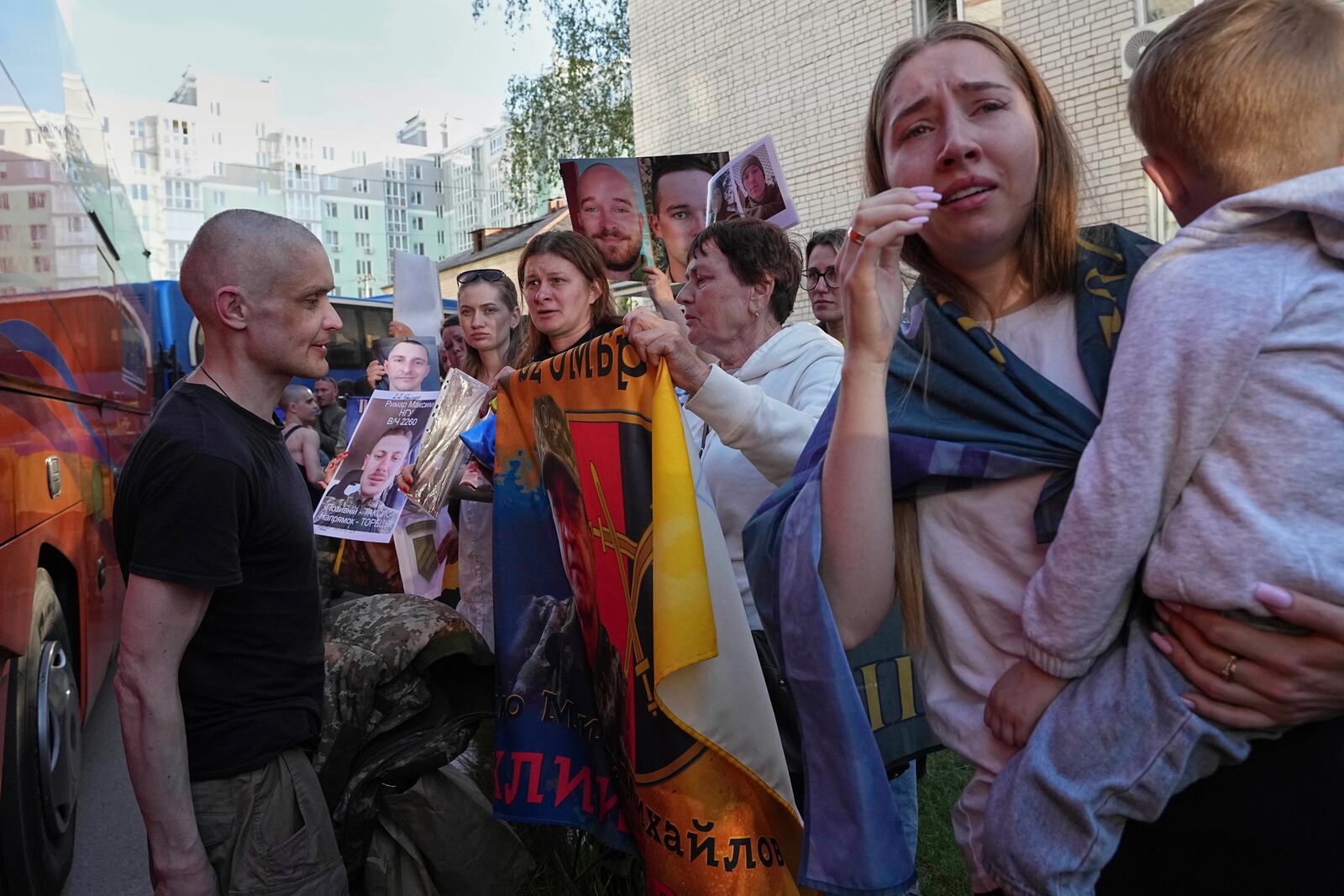Family members of Ukrainian prisoners hold photos of servicemen in captivity during a POWs exchange between Russia and Ukraine, in Chernyhiv region, Ukraine, Friday, May 23, 2025. (AP Photo/Efrem Lukatsky)
