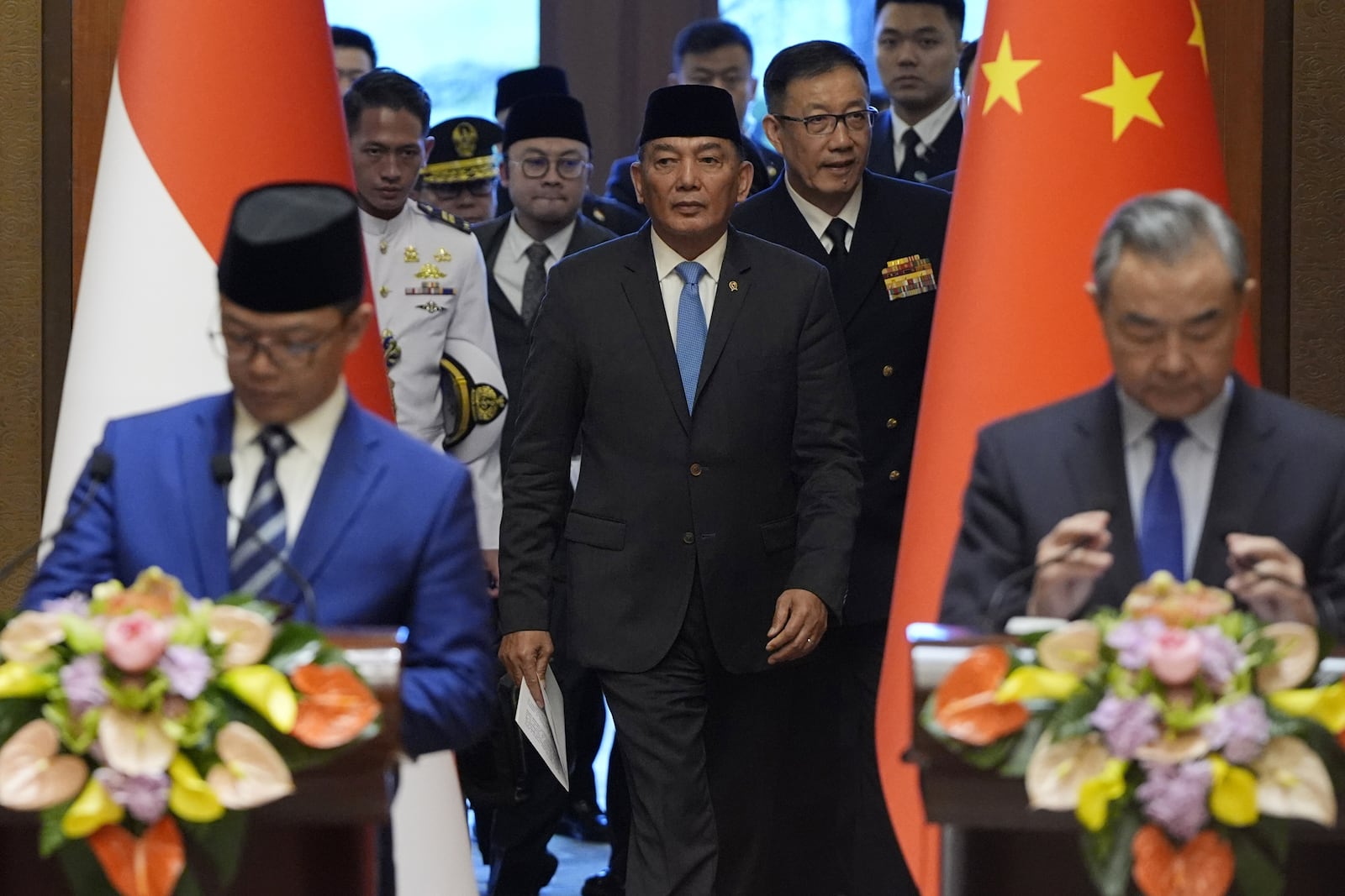 Indonesian Foreign Minister Sugiono, bottom left, Indonesian Defense Minister Sjafrie Sjamsoeddin, center left, Chinese Defense Minister Dong Jun, center right, and Chinese Foreign Minister Wang Yi, bottom right, arrive for a press briefing after the first meeting of China-Indonesia joint foreign and defense ministerial dialogue at the Diaoyutai State Guest House in Beijing Monday, April 21, 2025. (Iori Sagisawa/Pool Photo via AP)