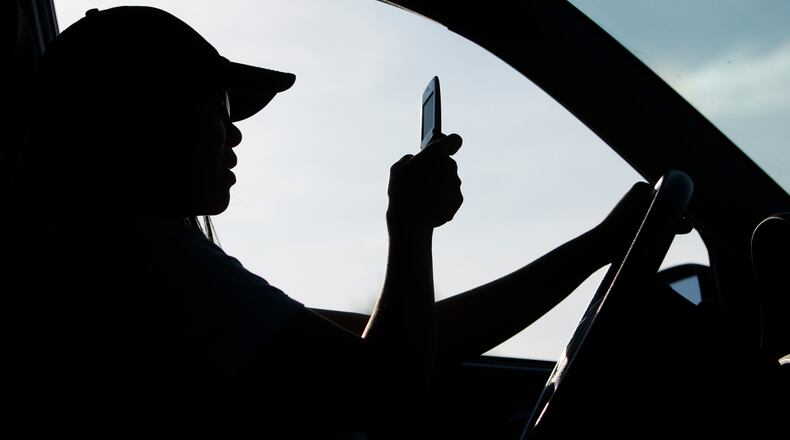 FILE - A driver uses a cell phone in Yarmouth, Maine, Sept. 8, 2009. New research indicates that state laws that are broadly worded to prohibit drivers from holding a cell phone under any circumstance appear to be effective in reducing rear-end crashes. The research paper, published by the Insurance Institute for Highway Safety on Tuesday, Aug. 9, 2022, looked at data from Oregon, Washington and California and compared it to Colorado and Idaho. (AP Photo/Robert F. Bukaty, File)