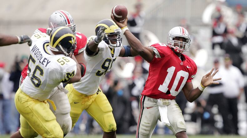 COLUMBUS, OH - NOVEMBER 20: Quarterback Troy Smith #10 of the Ohio State Buckeyes throws under pressure from defensive end LaMarr Woodley #56 and defensive tackle Marques Walton #95 of the Michigan Wolverines on November 20, 2004 at Ohio Stadium in Columbus, Ohio. Ohio State upset Michigan 37-21. (Photo by Brian Bahr/Getty Images)