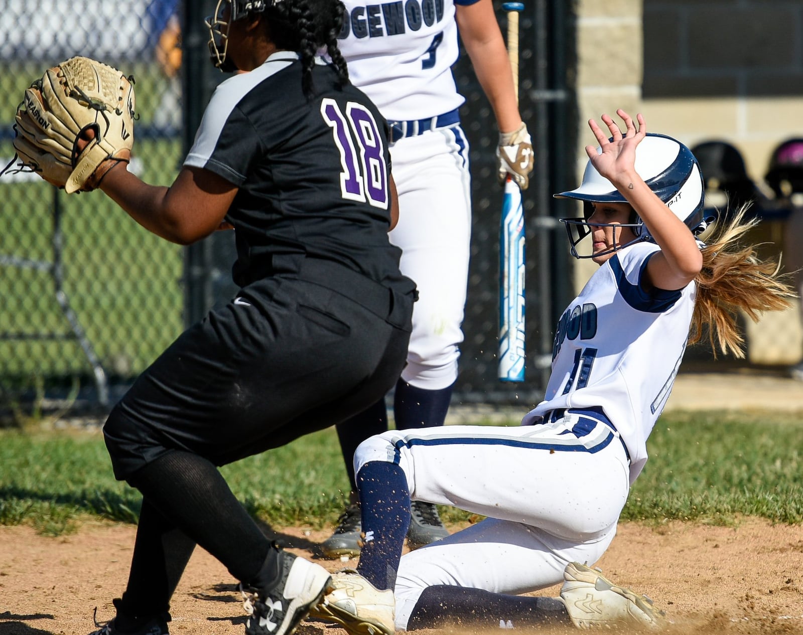 Edgewood’s Julya Dougherty slides safely into home plate as Middletown pitcher Eboney Sinclair tries to make the play Monday during a Division I sectional opener at Edgewood. NICK GRAHAM/STAFF