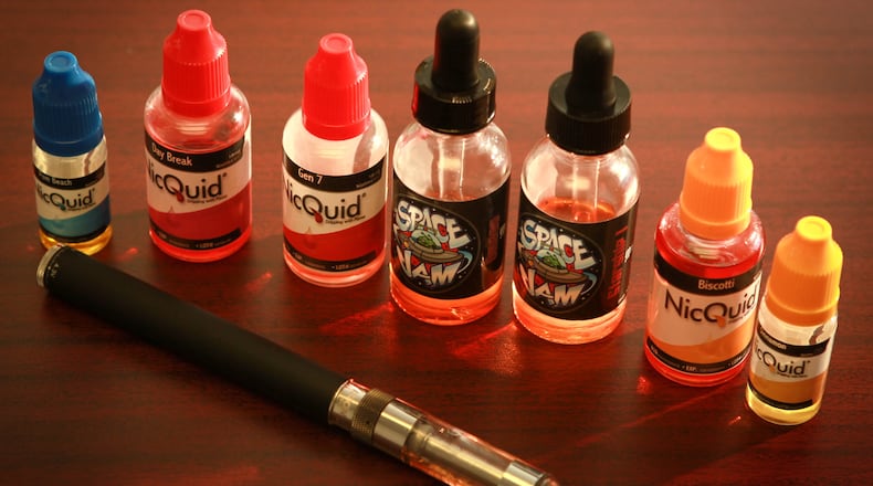 A collection of e-cigarette liquid and a battery-operated device. (Staff file photo)