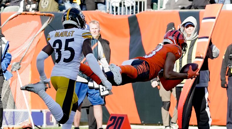Cincinnati Bengals wide receiver Tyler Boyd (83) makes a diving catch past Pittsburgh Steelers cornerback Arthur Maulet (35) during the first half of an NFL football game, Sunday, Nov. 28, 2021, in Cincinnati. (AP Photo/Jeff Dean)