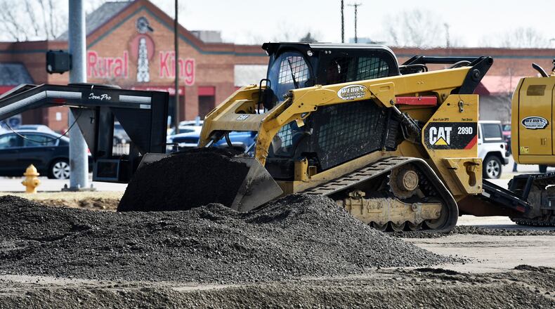 A worker with Webb’s Excavating was operating a compactor Tuesday on the site of a future Chipotle Mexican Grill on Main Street in Hamilton. MIKE RUTLEDGE/STAFF