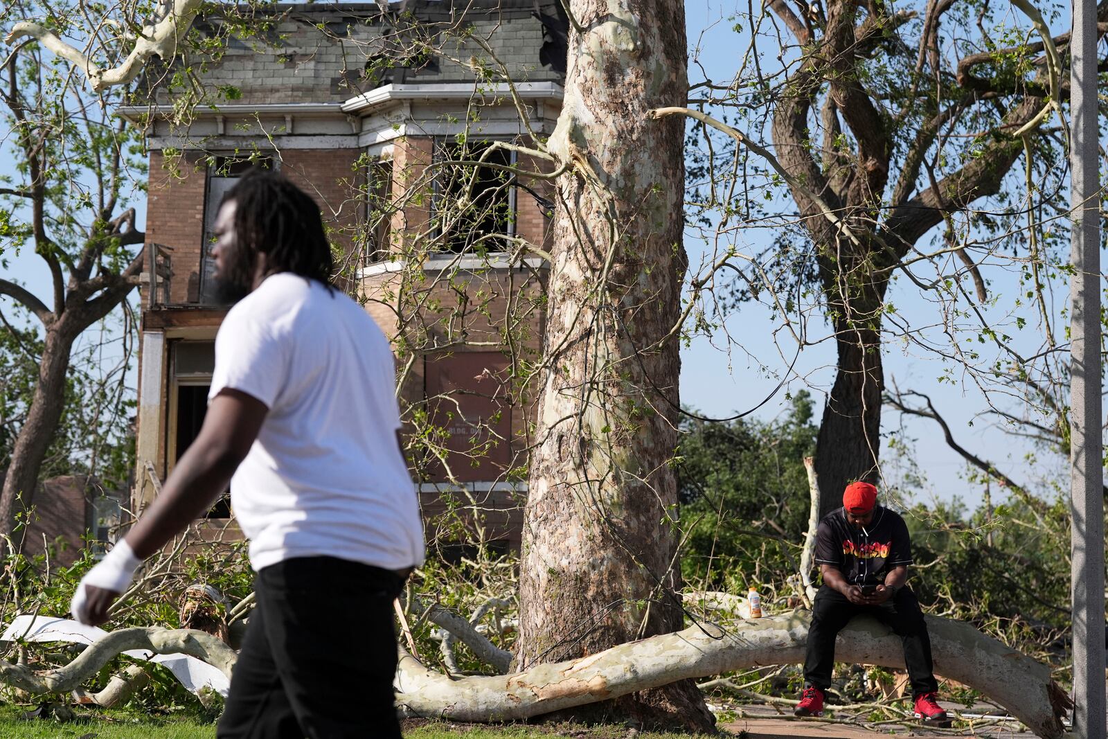 Steven Lampink sits on a downed tree after a severe storm moved through St. Louis, Missouri, Friday, May 16, 2025. (AP Photo/Jeff Roberson)