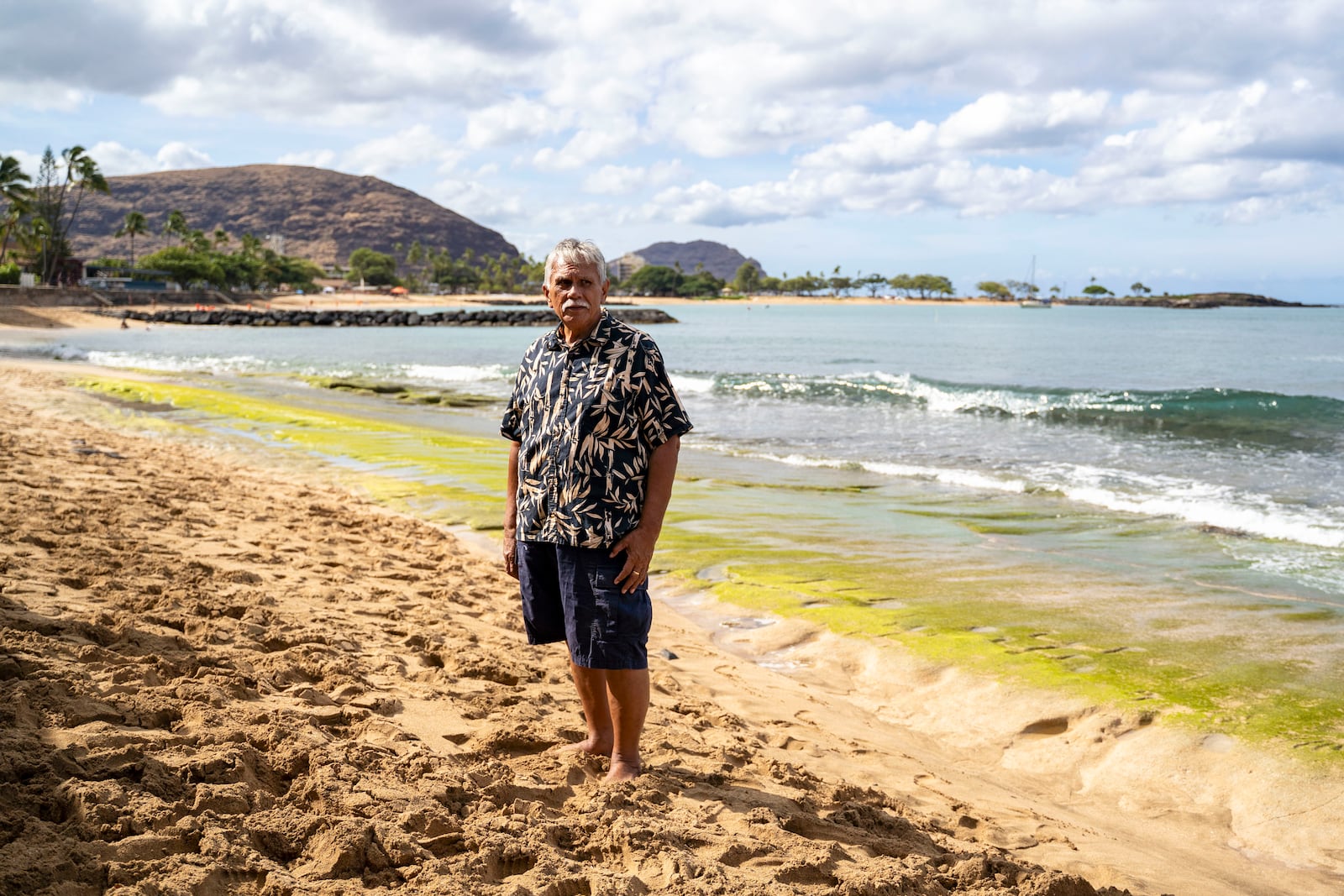Cultural practitioner Glen Kila poses for a portrait near the shoreline where ancient petroglyphs at Pokai Bay, July 22, 2025, in Waianae, Hawaii. (AP Photo/Mengshin Lin)