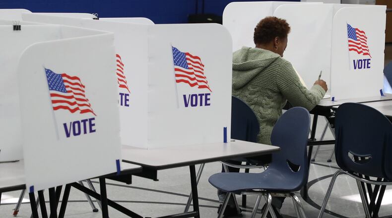 A woman casts her vote Tuesday at the Springfield election poll in Fulton Elementary School. BILL LACKEY/STAFF