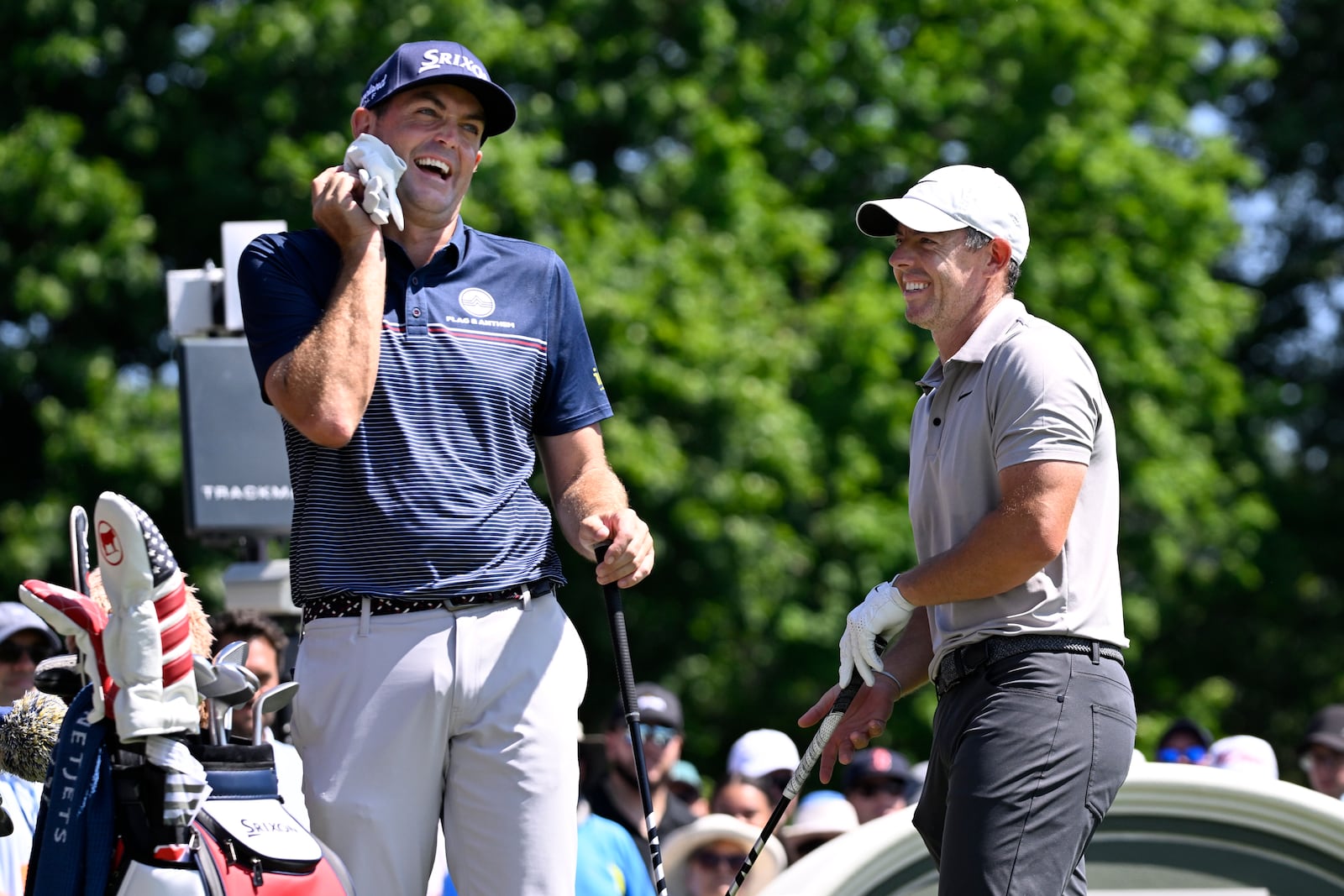 Keegan Bradley, left, shares a light moment with Rory McIlroy, of Northern Ireland, right, as they start the first round of the Travelers Championship golf tournament at TPC River Highlands, Thursday, June 19, 2025, in Cromwell, Conn. (AP Photo/Jessica Hill)