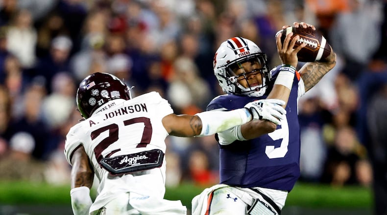 Auburn quarterback Robby Ashford (9) tries to elude a pursuit by Texas A&M defensive back Antonio Johnson (27) during the second half of an NCAA college football game Saturday, Nov. 12, 2022, in Auburn, Ala. (AP Photo/Butch Dill)