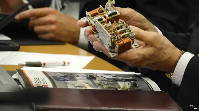 Fairfield Councilman Mike Snyder holds an assembly with two custom conductors in a custom frame designed for the military’s joint strike fighter program. MICHAEL PITMAN/STAFF
