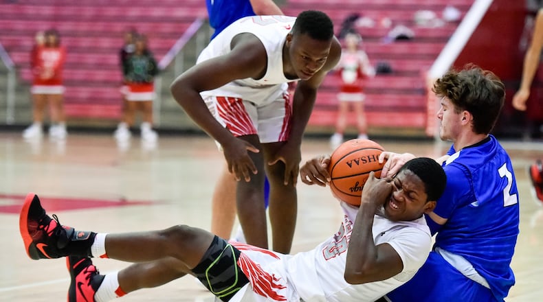 Hamilton’s Kurtis Reid (2) and Fairfield’s Allen Caldwell (22) fight for a loose ball as Farifield’s Courtland Smith looks on during Friday night’s game at the Fairfield Arena. Hamilton won 57-42. NICK GRAHAM/STAFF