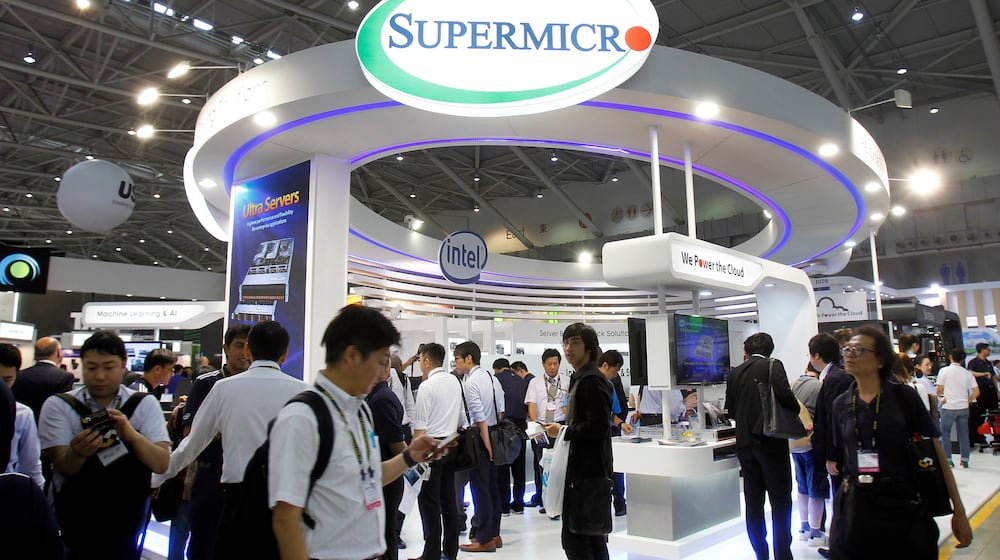 FILE - Visitors walk past a Super Micro Computer Inc. booth at the Computex Taipei exhibition in Taipei, Taiwan, June 5, 2018. (AP Photo/Chiang Ying-ying, File)