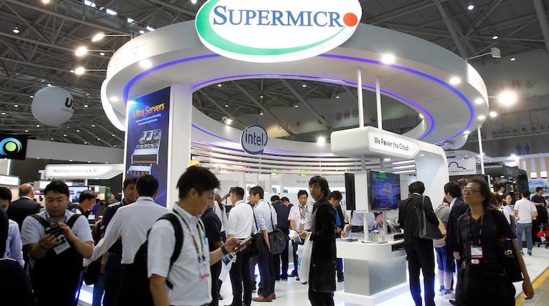FILE - Visitors walk past a Super Micro Computer Inc. booth at the Computex Taipei exhibition in Taipei, Taiwan, June 5, 2018. (AP Photo/Chiang Ying-ying, File)