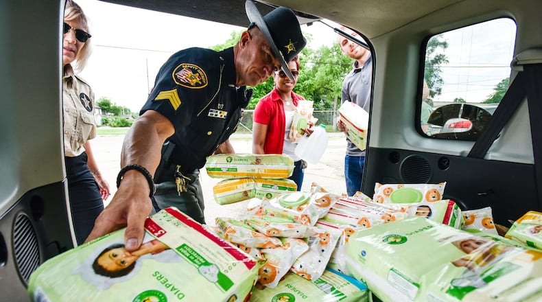 Butler County Sheriff’s Sgt. Reggie Bronnenberg helps unload diapers donated by Wayne’s Garage and Towing as the Butler County Sheriff’s Office collected nonperishable food, water and other items Friday to deliver to those hit by Monday night’s tornadoes in Montgomery, Miami and Greene counties. NICK GRAHAM / STAFF