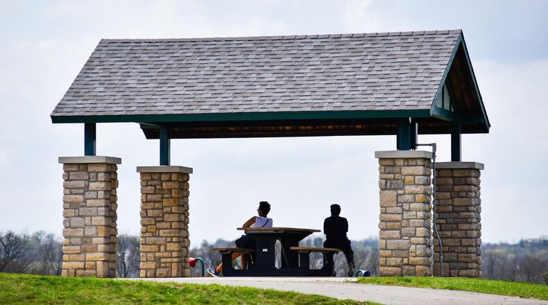 Two people take a break Tuesday, April 7, 2020 at Huffman Park in Fairfield. NICK GRAHAM / STAFF