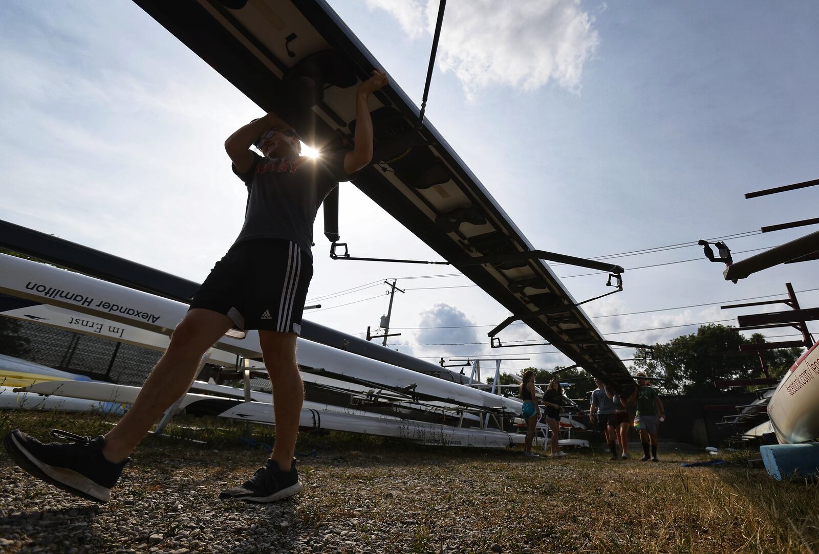 Great Miami Crew rowing team members get boats ready during practice Wednesday, Aug. 11, 2021 on the Great Miami River in Hamilton. NICK GRAHAM / STAFF
