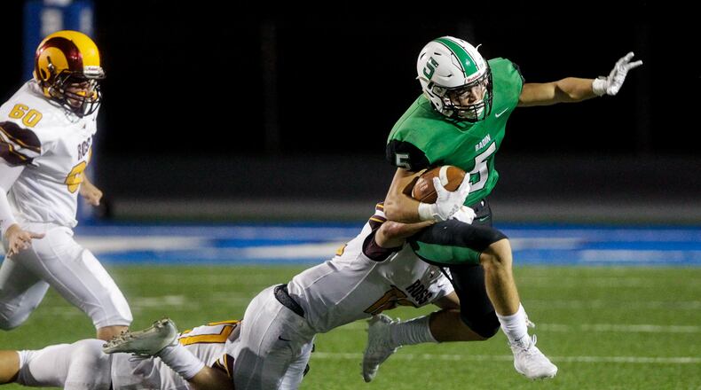 Badin’s Marshall Flaig carries the ball as Aaron Smith, from Ross, takes him down during their season opener football game against Ross Friday, August 30, 2019 at Hamilton’s Virgil Schwarm Stadium. Ross won 20-19 in overtime. NICK GRAHAM/STAFF