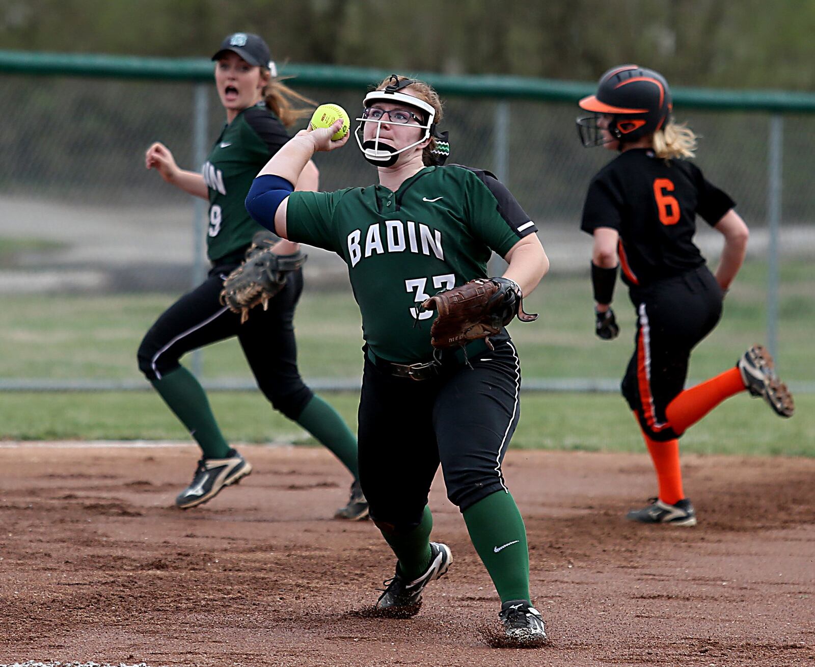 Badin third baseman Maddie Curtner fires to first as shortstop Shelby Schmitt runs to cover third in front of Wilmington’s Sophie Blessing during their game at Carl Schatt Field in Hamilton on March 27. CONTRIBUTED PHOTO BY E.L. HUBBARD