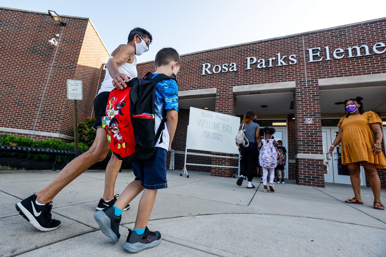 Danette Moore walks her grandson, Liam Lingenfelter, 6, in for the first day of school at Rosa Parks Elementary School Thursday, Aug. 12, 2021 in Middletown. A $10 million expansion was recently completed at the school housing mostly fourth and fifth grade classrooms, library, science area and multi-use open learning spaces. NICK GRAHAM / STAFF