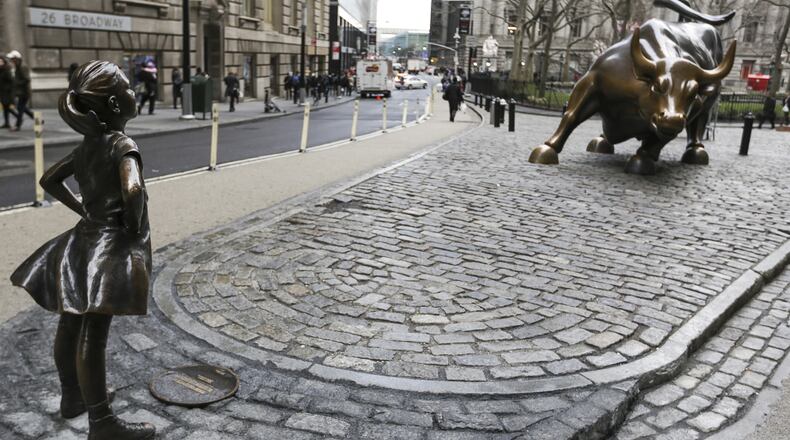 A bronze statue of a defiant girl faces “Charging Bull” in the Financial District of New York on International Womens Day, March 8, 2017. State Street Global Advisors, a unit of State Street Corp., installed the Kristen Visbal statue in front of Arturo Di Modica’s iconic charging bull by as part of its new campaign to pressure companies to add more women to their boards. (MUST CREDIT: Jeenah Moon/Bloomberg)