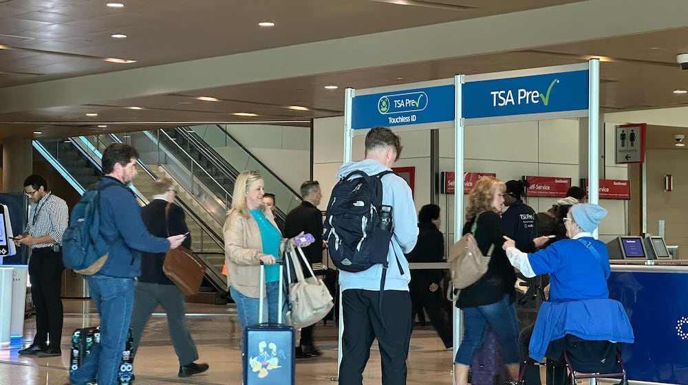 People walk through TSA PreCheck at Dallas Love Field on Sunday, Feb. 22, 2026. (AP Photo/Jamie Stengle)