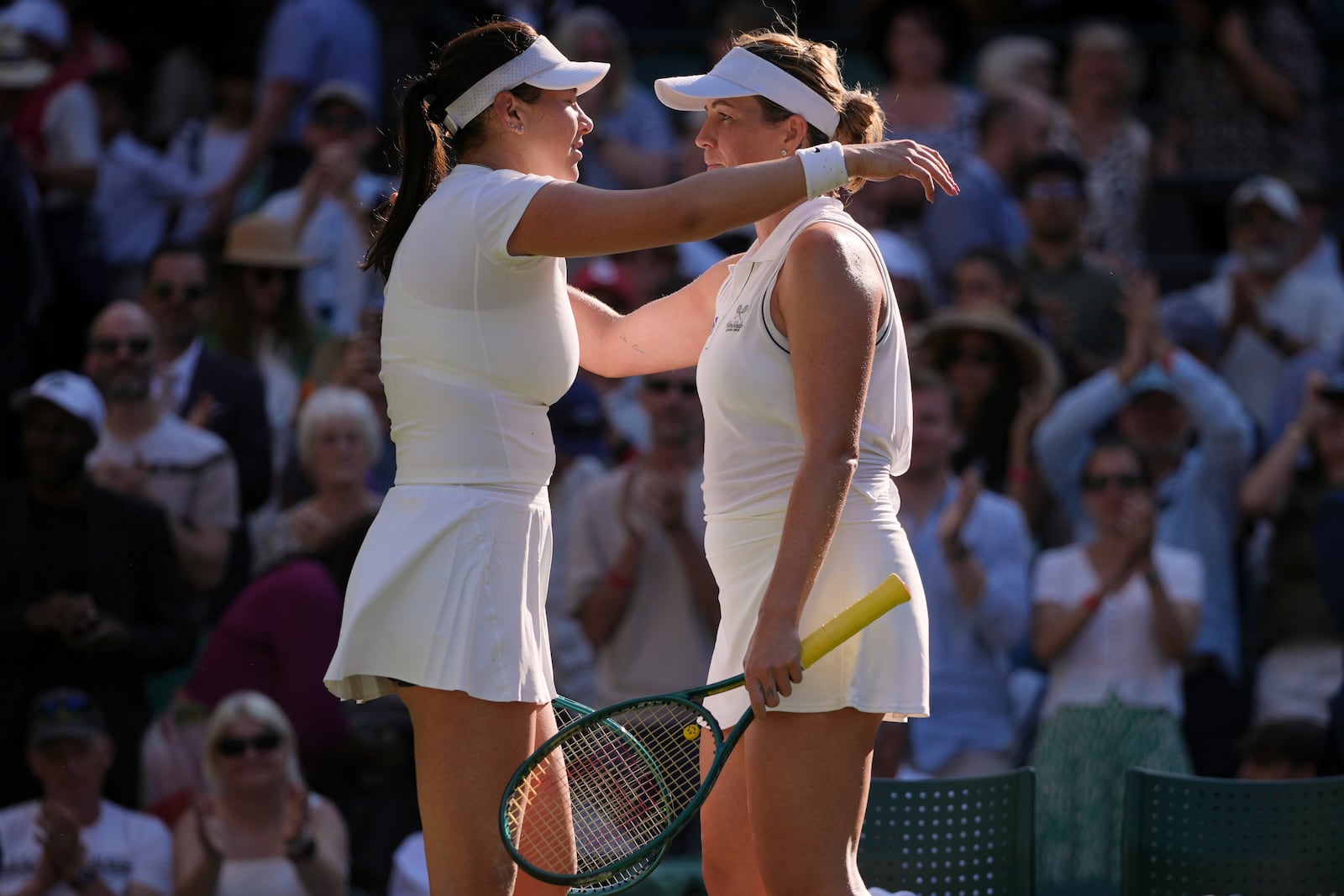 Anastasia Pavlyuchenkova of Russia, right, and Amanda Anisimova of the U.S. hug after the women's singles quarter finals match at the Wimbledon Tennis Championships in London, Tuesday, July 8, 2025.(AP Photo/Kin Cheung)