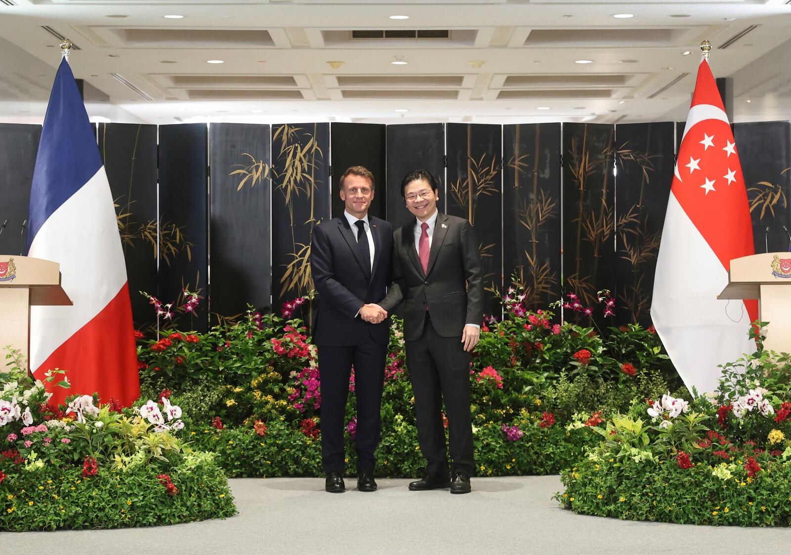 In this photo released by Singapore's Ministry of Digital Development and Information (MDDI), French President Emmanuel Macron, left, shakes hand with Singapore's Prime Minister Lawrence Wong during a joint press conference after ministers from both countries signed multiple bilateral agreements in Singapore, Friday, May 30, 2025.(MDDI via AP)