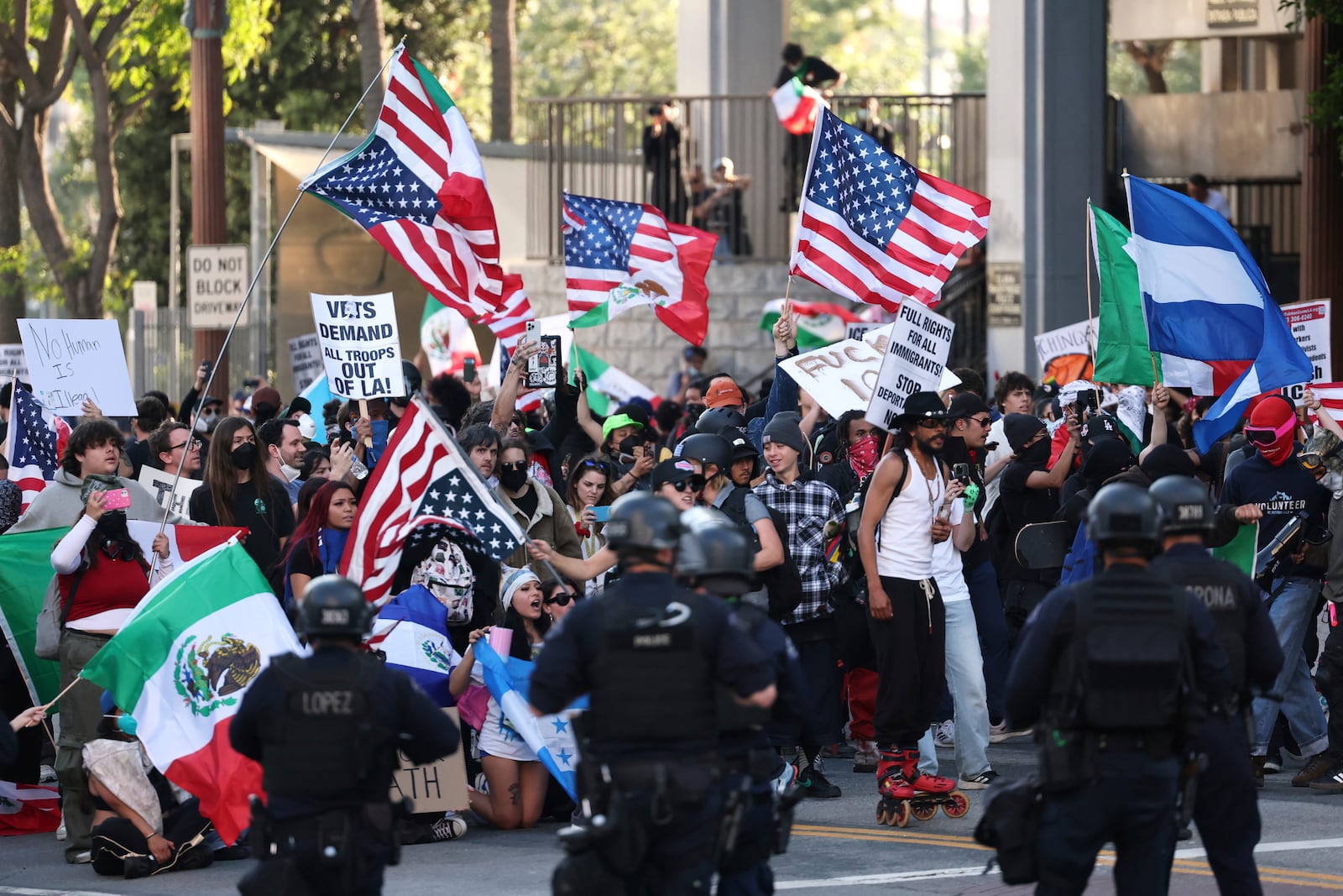 Law enforcement officers stand guard as demonstrators protest on Wednesday, June 11, 2025, in Los Angeles. (AP Photo/Ethan Swope)