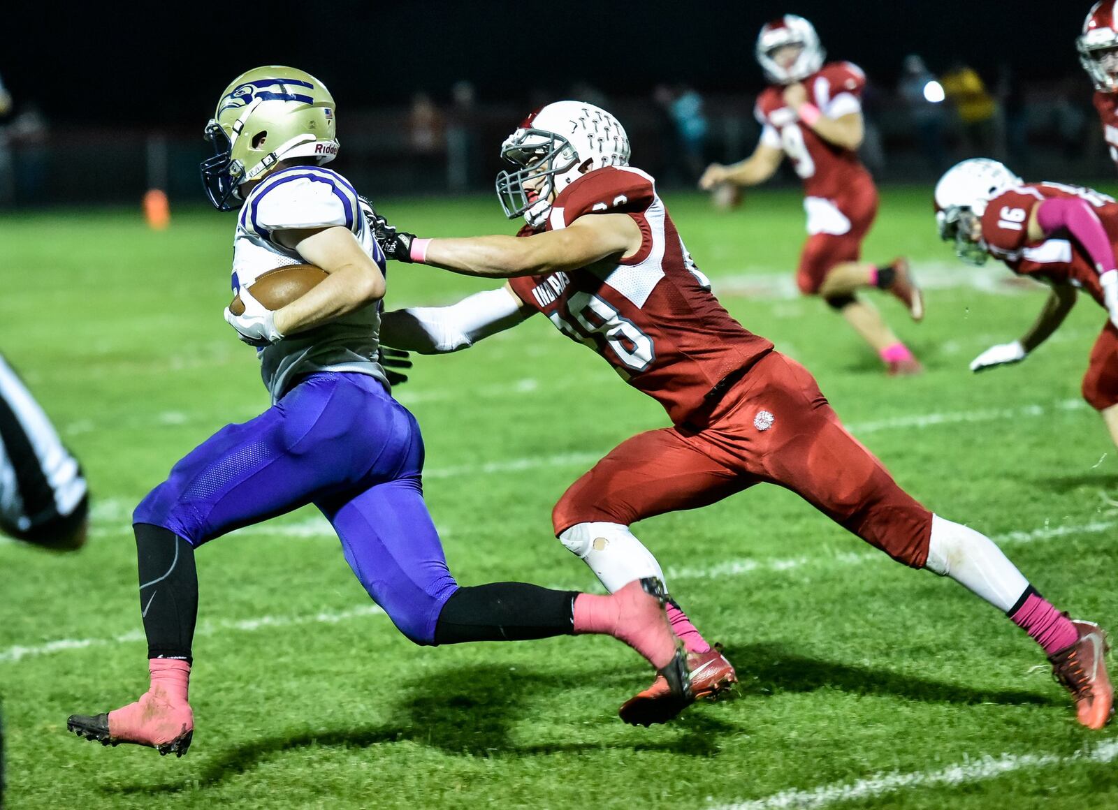 Eaton’s Caleb Puckett is about to be tackled by Carlisle’s Dane Flatter (28) on Thursday night at Laughlin Field in Carlisle. NICK GRAHAM/STAFF